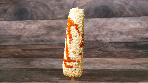 Corn on a stick topped with fresh cheese, margarine, mayonnaise, fresh lemon juice, and a spicy kick!